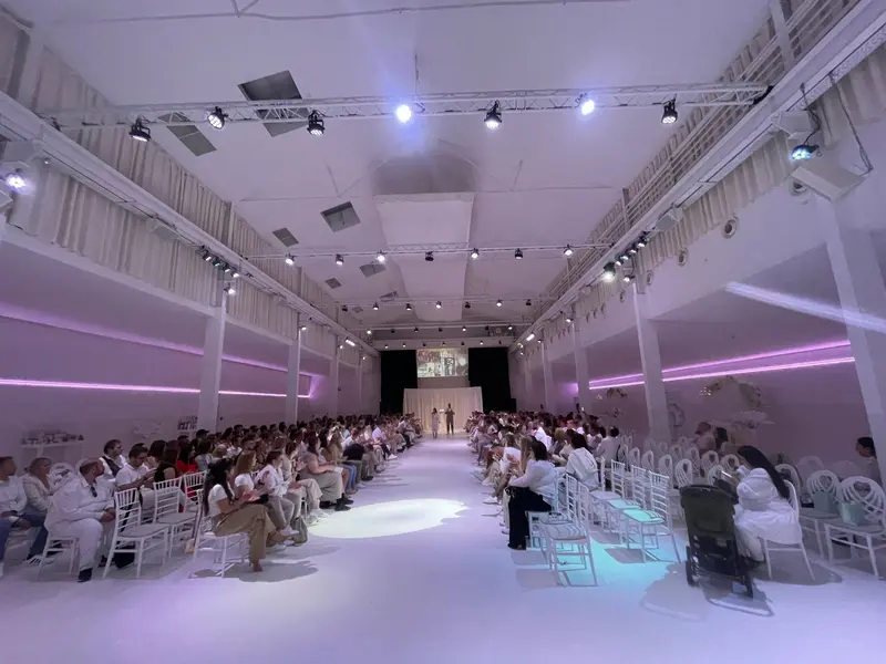 Voll besetzter Saal bei einer Präsentation mit Laufsteg